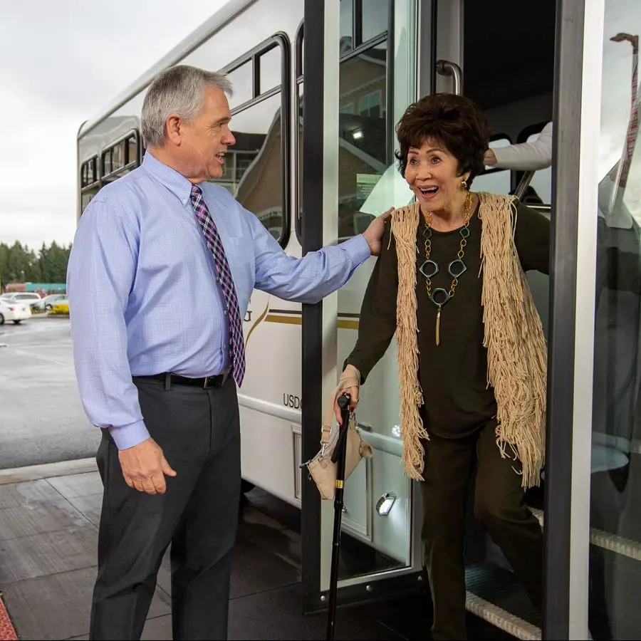 Alexis Estates man helping lady off bus